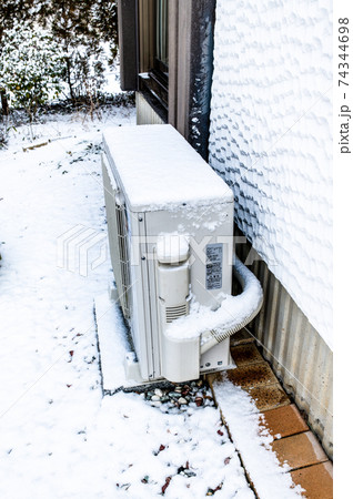 雪をかぶったエアコン室外機 雪をかぶったエアコン室外機 74344698