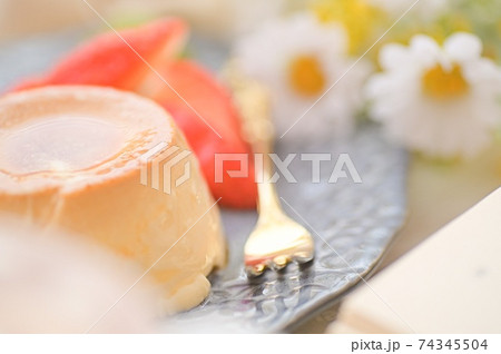 マクロレンズで撮影した お洒落なお皿にのったイチゴとプリンの写真素材