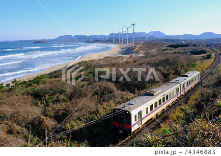 山陰本線を走る列車と風車の立ち並ぶ海岸線：島根県江津市 74346883