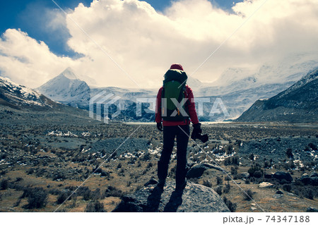 Woman hiker with camera in winter high altitude mountains 74347188