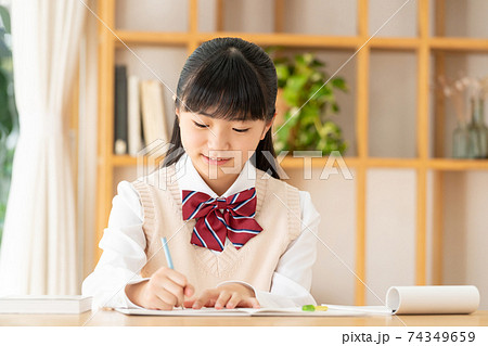 リビングで勉強をする制服の女の子の写真素材