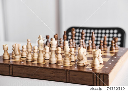 Chess board with chess pieces on table. Everything is ready for game battle Chess board with chess pieces on table. Everything is ready for game battle 74350510