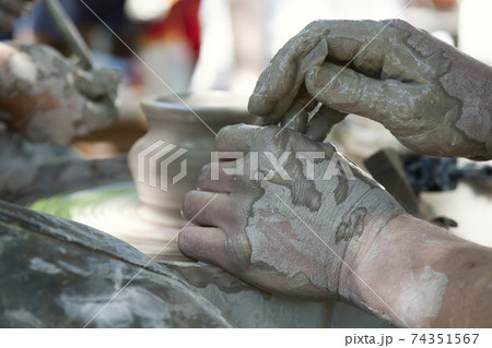 Potter shaping a ceramic pot on a pottery wheel Potter shaping a ceramic pot on a pottery wheel 74351567