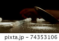 MACRO: Drug addiction. Syringe, Sprinkled white powder. Human hand on background. 74353106