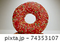 MACRO: Pink donut stands on a white dish 74353107