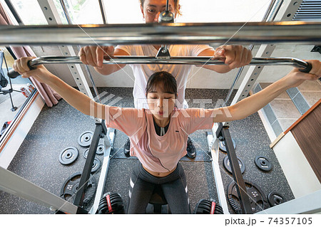 パーソナルトレーニングジムでトレーニングする女性 74357105