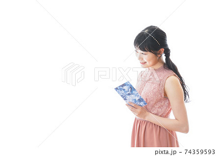 パーティーの招待状を持つ若い女性 74359593