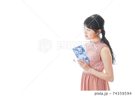 パーティーの招待状を持つ若い女性 74359594