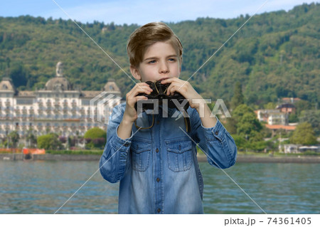 Portrait of thoughtful little boy looking through binoculars. Portrait of thoughtful little boy looking through binoculars. 74361405