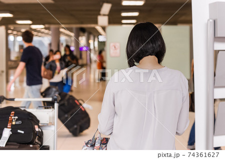 Woman toruist at the airport with tluggage waiting for departure. Woman toruist at the airport with tluggage waiting for departure. 74361627