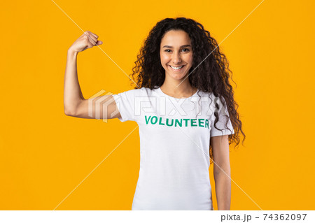 Volunteer Lady Posing Showing Biceps Standing Over Yellow Background 74362097