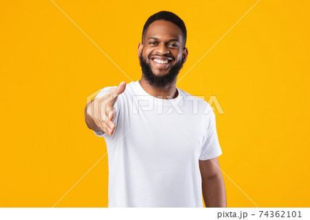 Happy African American Man Offering Hand For Handshake, Yellow Background Happy African American Man Offering Hand For Handshake, Yellow Background 74362101