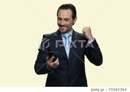 Businessman looking on his phone and celebrating success. Businessman looking on his phone and celebrating success. 74362364