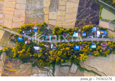 Top view of rural village surrounded by rice field in Nan province, Thailand Top view of rural village surrounded by rice field in Nan province, Thailand 74363276