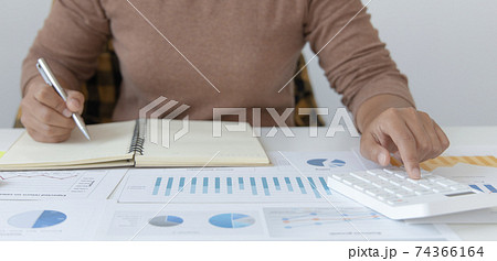 Head of accounting is recording the company's financial growth statistics using graphs as a reference for reviewing and analyzing the results, Taking notes and analyzing data graphs in office. 74366164