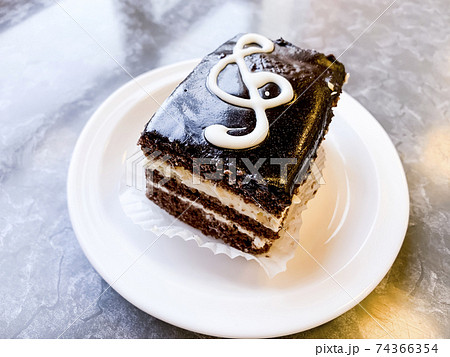 Piece of delicious cake decorated with treble clef. Studio Photo Piece of delicious cake decorated with treble clef. Studio Photo 74366354