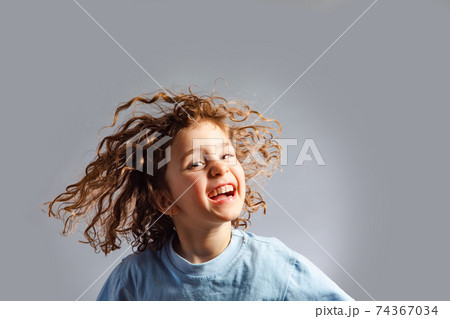 little girl jumps on a gray background 74367034