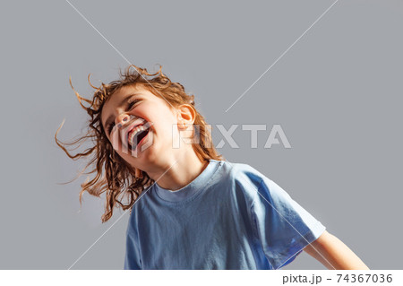 little girl jumps on a gray background 74367036