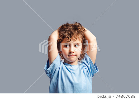 Little girl stand and thinking on a gray background 74367038