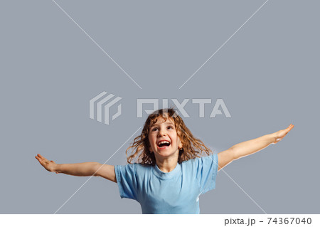 little girl jumps on a gray background 74367040
