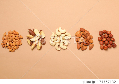 Set of different nuts on light beige background, top view 74367132