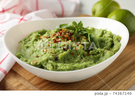 Bowl with guacamole, spices and basil, close up Bowl with guacamole, spices and basil, close up 74367140