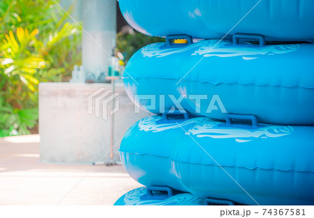 Large stack of blue swim ring for water park slide on water park pool side. Large stack of blue swim ring for water park slide on water park pool side. 74367581