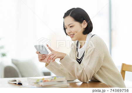 スマホを見ながら勉強をする高校生 74369756