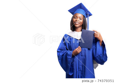 Black woman in a blue robe on a white background smiles and shows diploma Black woman in a blue robe on a white background smiles and shows diploma 74370351