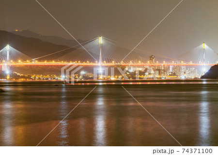Suspension bridge on the city background at night time. 74371100