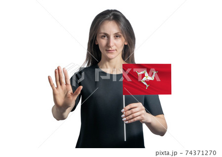 Happy young white woman holding flag of Isle of Man and with a serious face shows a hand stop sign isolated on a white background Happy young white woman holding flag of Isle of Man and with a serious face shows a hand stop sign isolated on a white background 74371270