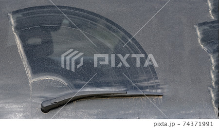 rear window of a dirty car covered with a layer of dry dirt defective wiper off road vehicle. rear window of a dirty car covered with a layer of dry dirt defective wiper off road vehicle. 74371991