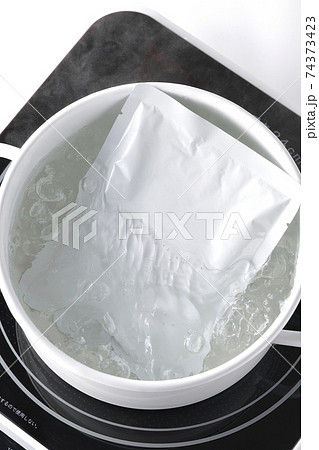 IHクッキングヒーターを使いレトルトパックを白い鍋で温める（俯瞰） 74373423