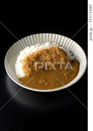 大きい豚カツが真ん中に一枚乗っているカツカレーを黒背景で撮影 74373980
