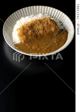 大きい豚カツが真ん中に一枚乗っているカツカレーを黒背景で撮影 大きい豚カツが真ん中に一枚乗っているカツカレーを黒背景で撮影 74373981