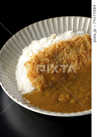 大きい豚カツが真ん中に一枚乗っているカツカレーを黒背景で撮影 大きい豚カツが真ん中に一枚乗っているカツカレーを黒背景で撮影 74373984