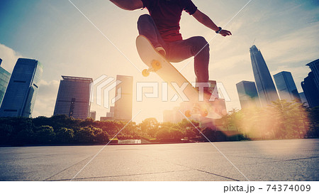 Asian woman skateboarder skateboarding in modern city 74374009