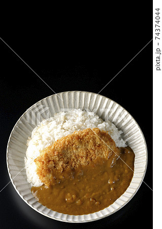 大きい豚カツが真ん中に一枚乗っているカツカレーを黒背景で撮影（俯瞰） 74374044