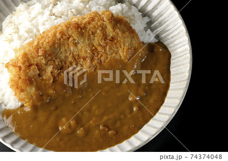大きい豚カツが真ん中に一枚乗っているカツカレーを黒背景で撮影(俯瞰) 大きい豚カツが真ん中に一枚乗っているカツカレーを黒背景で撮影(俯瞰) 74374048