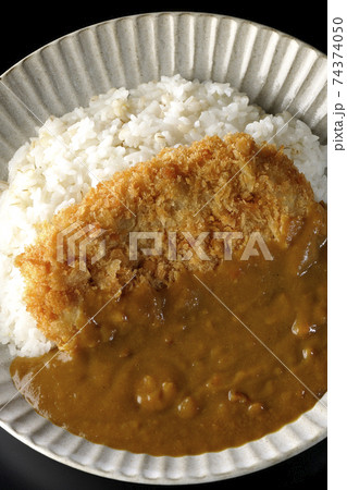 大きい豚カツが真ん中に一枚乗っているカツカレーを黒背景で撮影(俯瞰) 大きい豚カツが真ん中に一枚乗っているカツカレーを黒背景で撮影(俯瞰) 74374050
