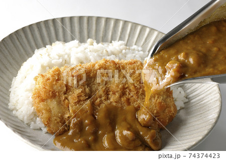 豚カツが乗っているご飯の上にカレーのルーをかける 豚カツが乗っているご飯の上にカレーのルーをかける 74374423