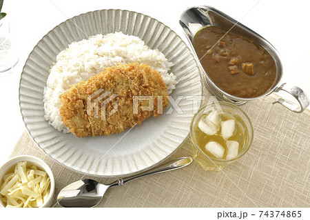 豚カツが乗ったご飯とルーが入ったカレーポットとトッピングのチーズとお茶とオリーブの葉（俯瞰） 74374865