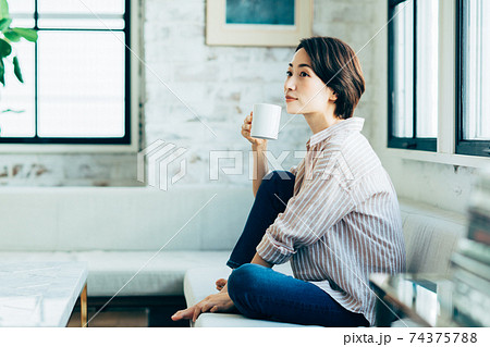 リビングでコーヒーを飲むミドルの女性 74375788