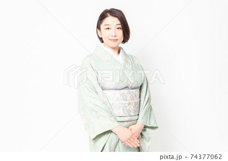 白背景の前に立つ着物を着た女性の写真素材