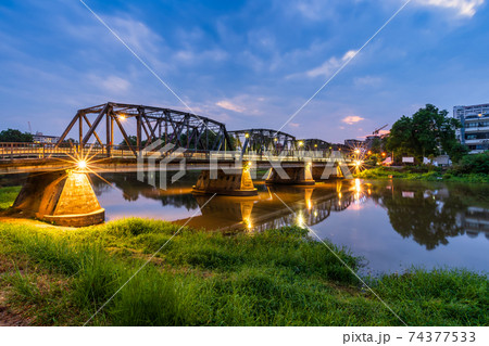 The color of the lights on the Iron Bridge at twlight time is a major tourist attraction in Chiang Mai,Thailand. The color of the lights on the Iron Bridge at twlight time is a major tourist attraction in Chiang Mai,Thailand. 74377533