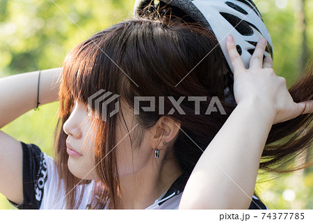 ヘルメットを外して髪がなびく女性アスリートの写真素材