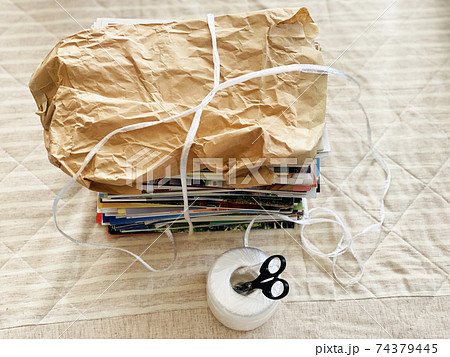 束ねたクラフト古紙とビニール紐とはさみ 74379445