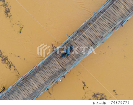 Aerial view of old wooden bridge over the river. Drone 74379775