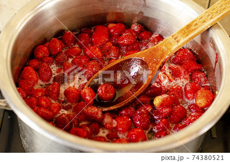 Strawberries are boiled with sugar in pan. 74380521
