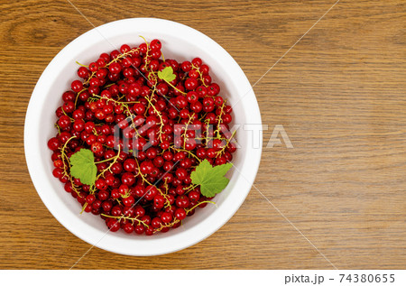 Ripe red currants in white bowl. Photo 74380655